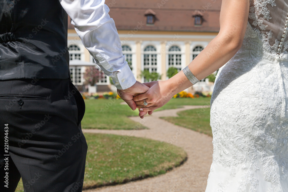 Newlyweds holding hands in a beautiful Park Newlyweds holding hands in a beautiful Park