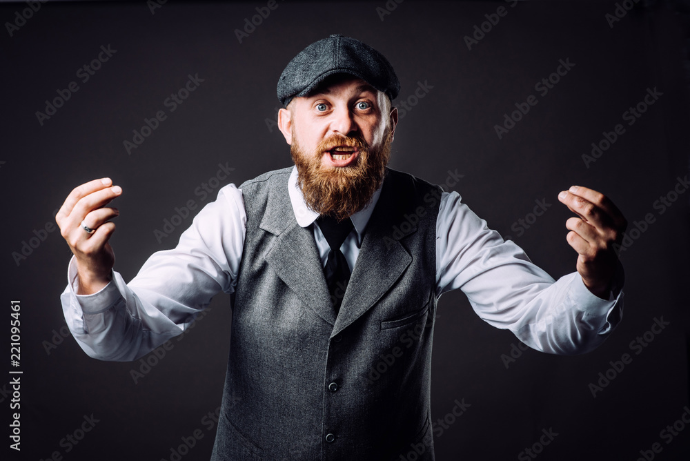 A bearded man in suit talking and gesticulating like italian on black background A bearded man in suit talking and gesticulating like italian on black background