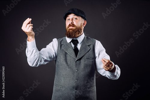 Φωτογραφία A bearded man in suit talking and gesticulating like italian on black background