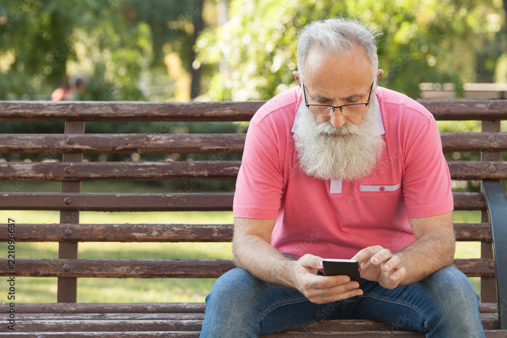 Fototapeta premium Senior man enjoying his smartphone outdoor