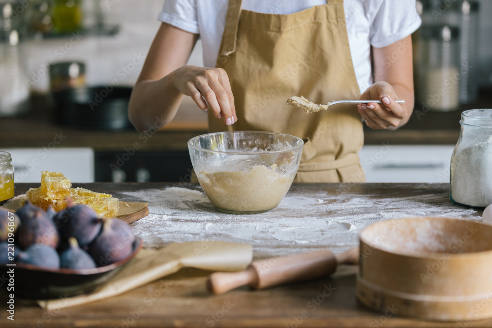 cropped shot of woman preparing dough for fig pie on rustic wooden table