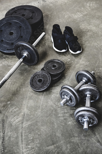 high angle view of various gym equipment and sneakers on concrete floor