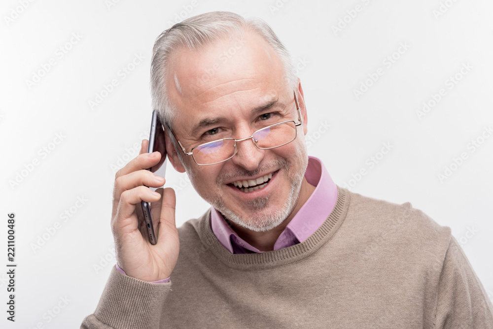 Happy man. Image without face retouching with handsome bearded senior man feeling happy while having phone conversation Happy man. Image without face retouching with handsome bearded senior man feeling happy while having phone conversation
