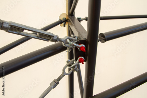 Hinged-clutch connection in metal structures. Connection of metal loops, staples and hinges. Fastening and stabilization of metal racks.