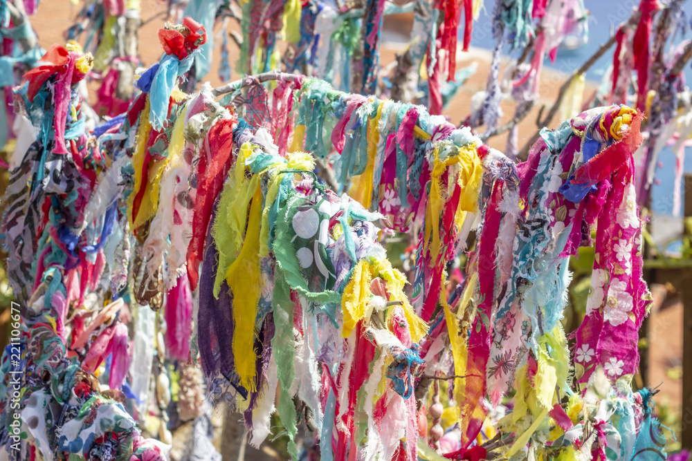Colorful scarfs are hanged on the branches of tree for the purpose of oblation