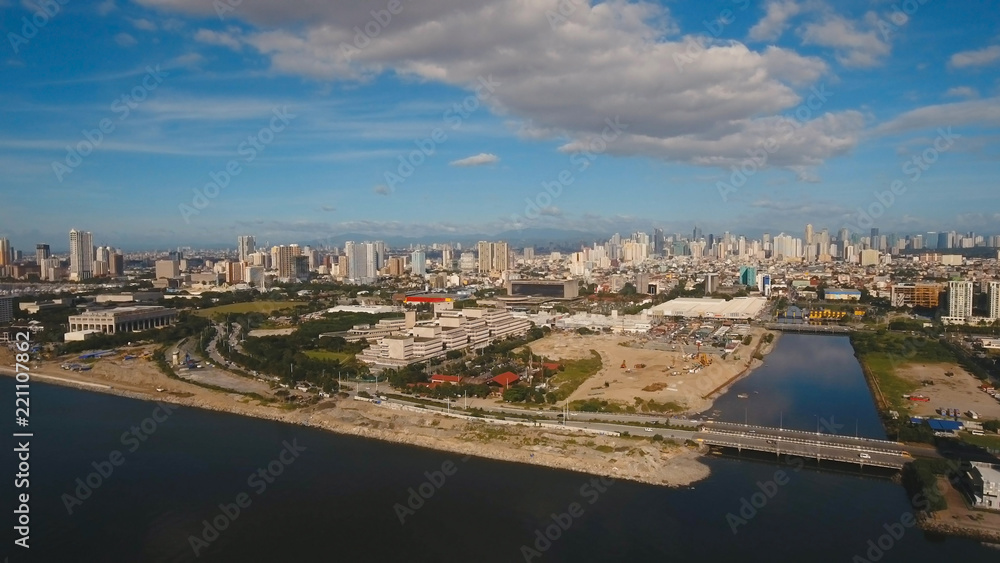 Aerial view skyline of Manila city, Makati. Fly over city with skyscrapers and buildings. Aerial skyline of Manila. Modern city by sea, highway, cars, skyscrapers, shopping malls. Travel concept.