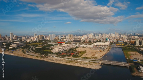 Aerial view skyline of Manila city, Makati. Fly over city with skyscrapers and buildings. Aerial skyline of Manila. Modern city by sea, highway, cars, skyscrapers, shopping malls. Travel concept.