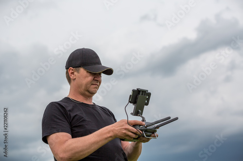 Man controls a quadrocopter. Selective focus on men, drone is blurred photo