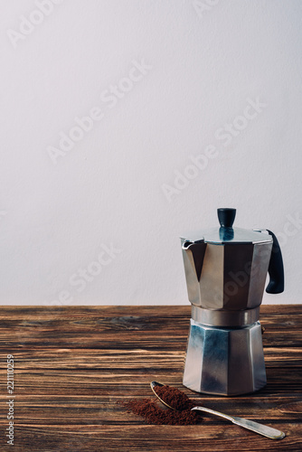 mocha pot and grinded coffee on rustic wooden table photo