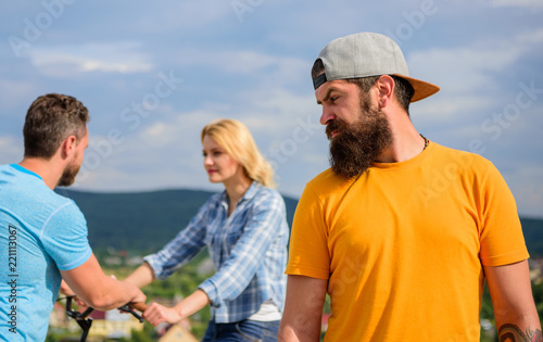 Guy adult still lonely while friends happy family life. Hipster sad face in front of couple in love. Unlucky romantic life. Man hipster feels lonely couple dating behind him. No romantic in his life © be free
