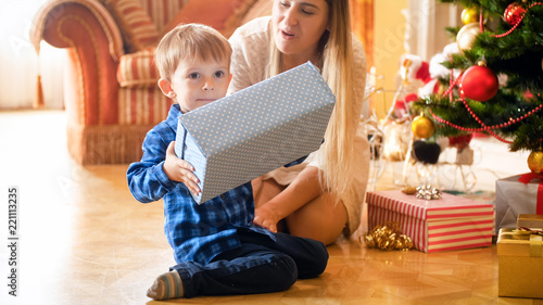 Portrait of little toddler boy holding Christmas gift box