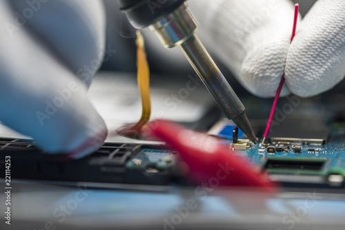 man hands, working on a electronic device, welding