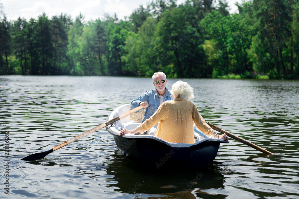 River trip. Couple of happy pensioners wearing fashionable clothes enjoying their amazing river trip