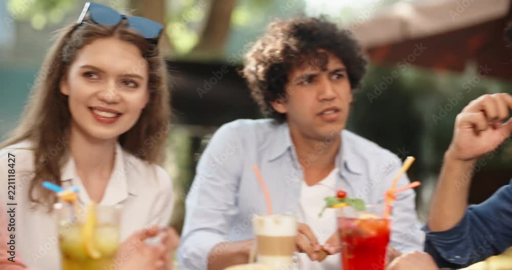 Group of multiethnic friends sitting at table in cafe outdoors, chatting, laughing, enjoying their time 4k Group of multiethnic friends sitting at table in cafe outdoors, chatting, laughing, enjoying their time 4k