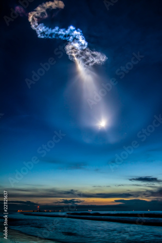A SpaceX Falcon 9 rocket carrying a Dragon cargo ship for the International Space Station launches, creating amazing noctilucent light effects in sky over Cape Canaveral, Florida photo