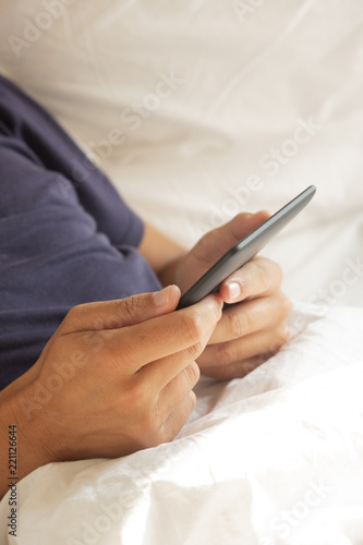 man using a tablet or an e-reader in bed