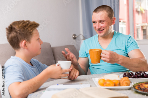 Man with his son are talking about life together in time lunch