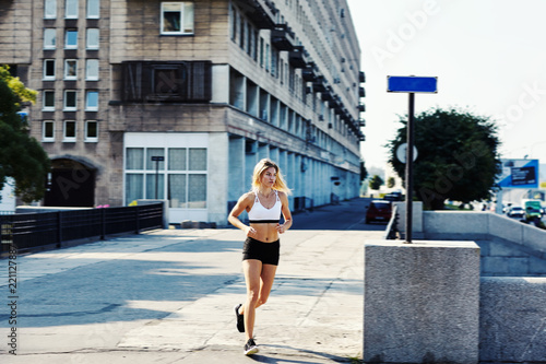 Young woman running on city street