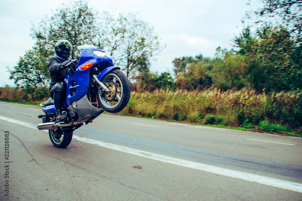 Obraz premium Dark blue motorbike on wheelie. Motorcycle on the parking lot. Ukraine, Lviv.