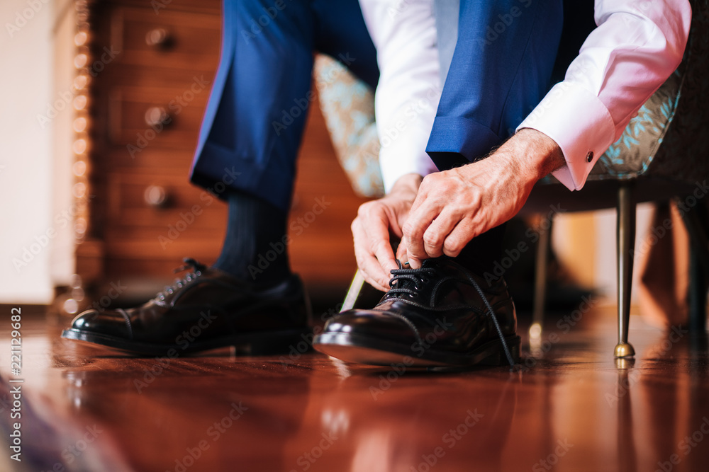 Datail of a groom putting on his shoes Datail of a groom putting on his shoes