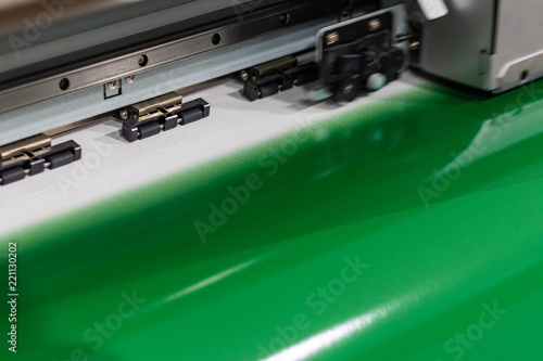 Big professional oversized printer, outputting a deep green glossy color sample sheet for best quality and performance.