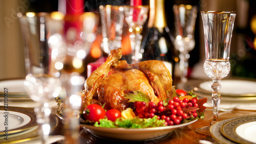 Fototapeta Naklejka Na Ścianę i Meble -  Closeup image of glasses, champagne and baked hot chicken on festive dinner