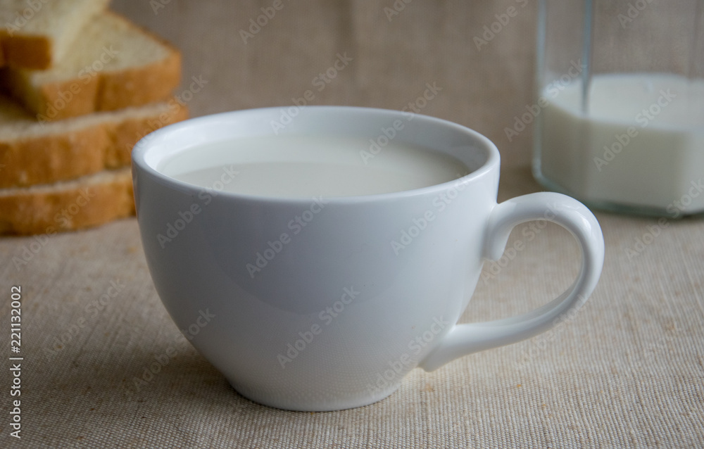 A cup of milk and pieces of white bread. A cup of milk and pieces of white bread.