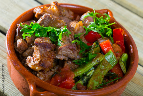 Tasty gyuvech dish of bulgarian cuisine with beef and vegetables at clay pot