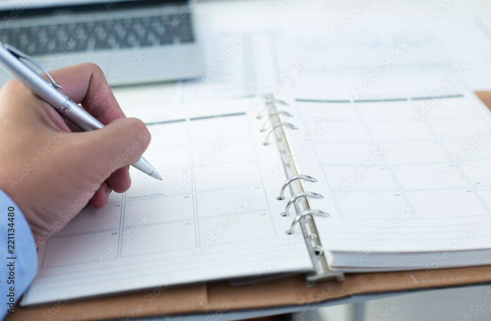 People hand holding pen closeup on open diary book closeup blur background, business, People hand holding pen closeup on open diary book closeup blur background, business,
