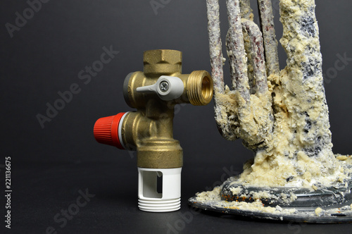 Hydraulic safety group and water heater resistance damaged by a problem of limescale. Pressure relief valve. photo