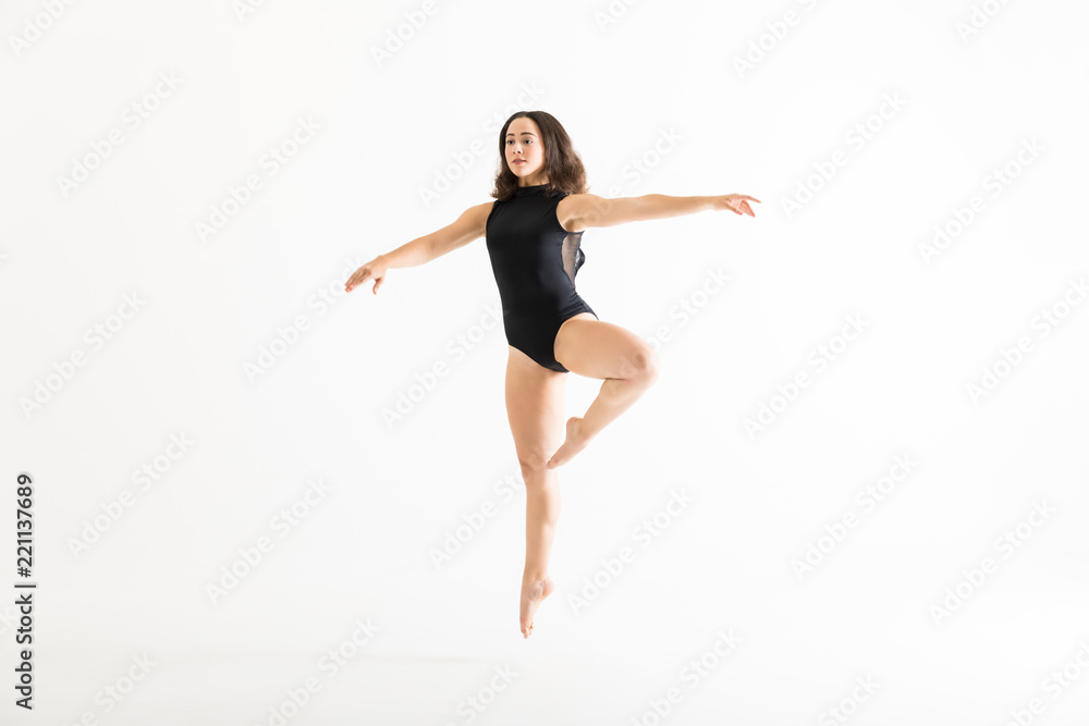 Attractive Ballerina In Midair With Arms Outstretched