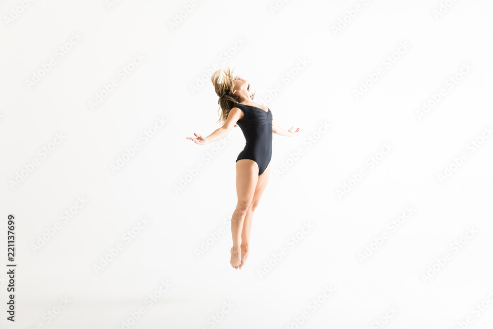 Ballerina In Flight Showing Dancing Skills Against Plain Background Ballerina In Flight Showing Dancing Skills Against Plain Background