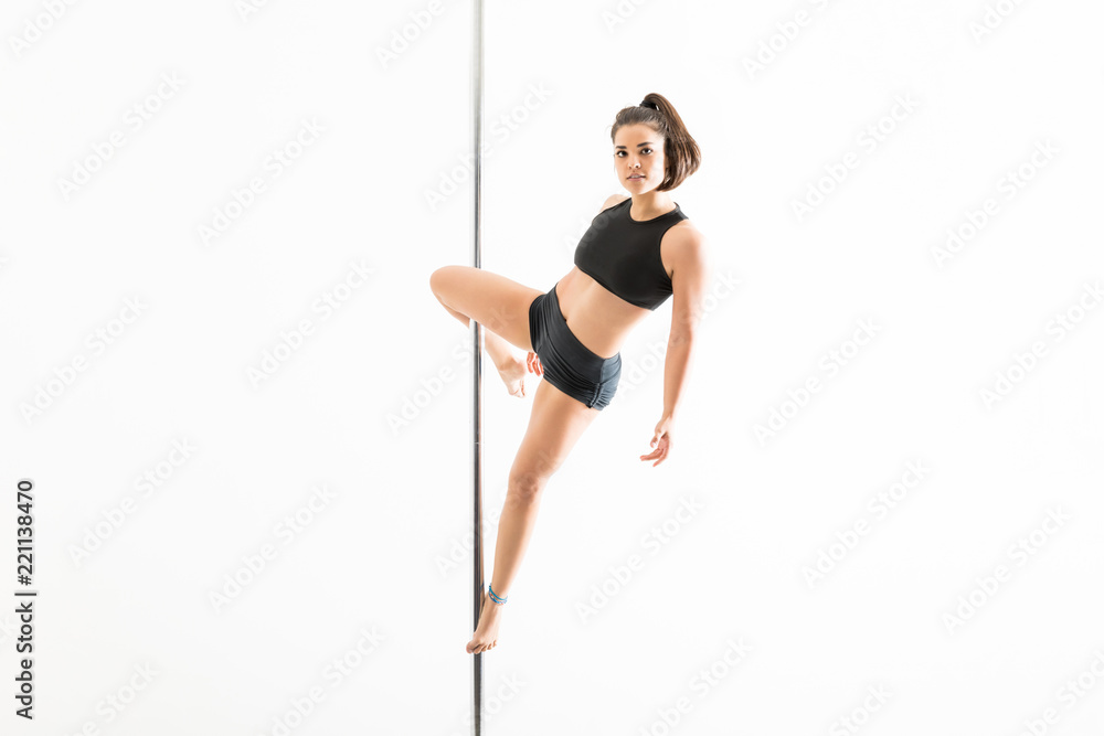 Foto Stock Pole Dance Expert Balancing In Cupid Position | Adobe Stock