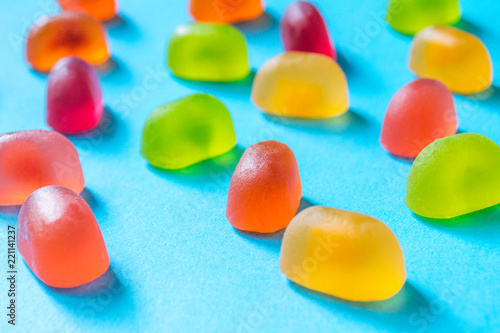 Multicolored gummy candies on a blue background