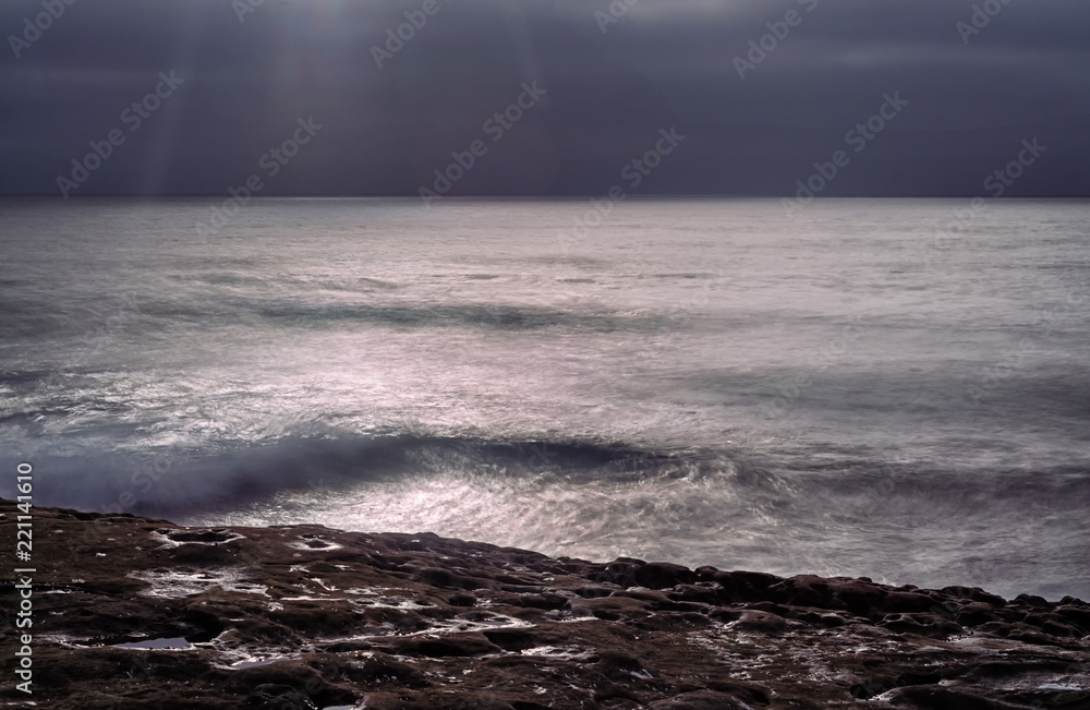 Silky ocean contrasting with the solid rock shoreline