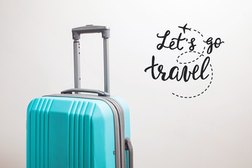 Suitcase on the white background and inspirational travel quote.