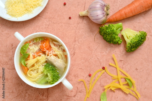 Chicken soup with vegetables and noodles, top view, copy space