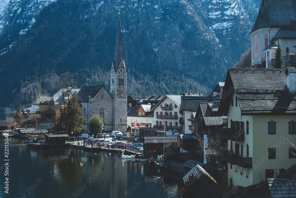 Fototapeta premium Belfry of the church against white mountains. Hallstatt village in Austria. Popular bay view