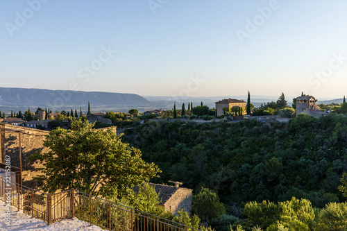 scenic view of traditional houses  green vegetation and distant mountains in provence  france