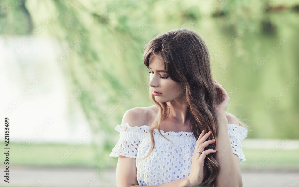 Portrait of a beautiful girl in a white dress in a field at sunset in summer. copy space Portrait of a beautiful girl in a white dress in a field at sunset in summer. copy space