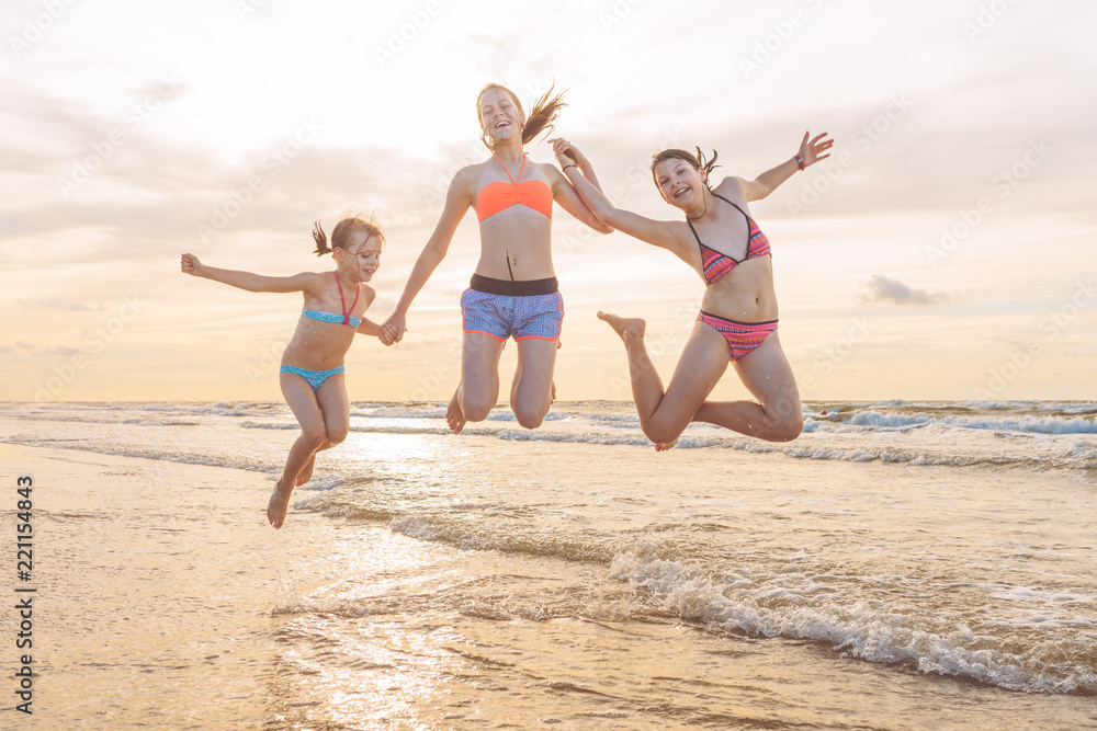 Kids having fun at sunset beach - friendship freedom beach summer holiday concept
