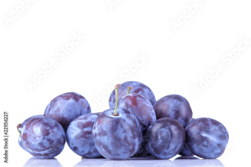 fresh ripe delicious plums stacked in a pile on a white isolated background
