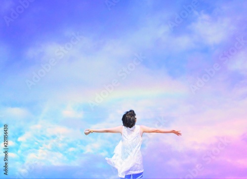 Woman under beautiful rainbow sky background.