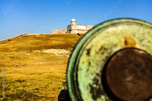 Castle San Pedro de la Roca del Morro, in Santiago de Cuba, Cuba. Big out of focus canon in the foreground.  photo