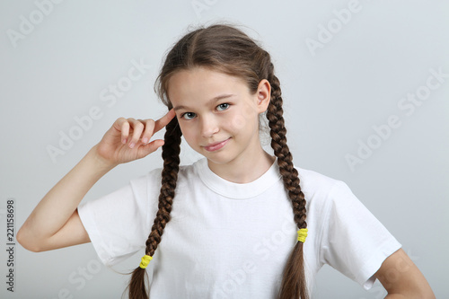 Cute young girl on grey background