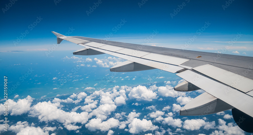 A view from the airplane window over the wings and engines  The planes are flying above the clouds and sky in transportation or travel concept.