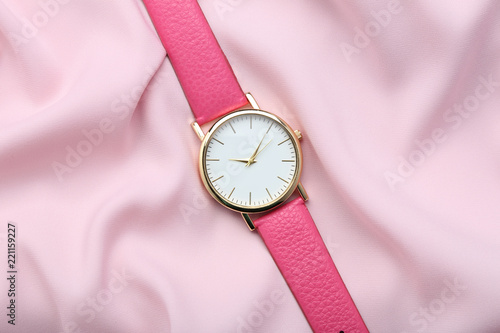 Wrist watch on pink satin background