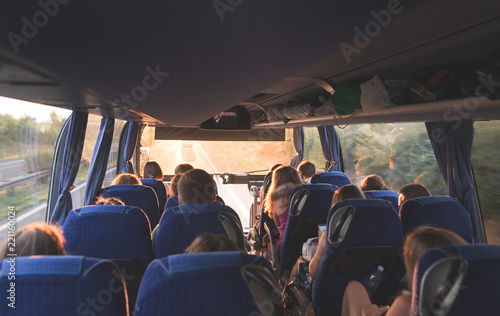 Tourist tour on the bus. People travel by bus. Salon of the great tourist bus with people at sunset photo