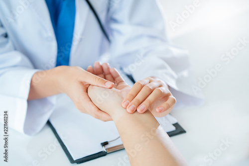 Vászonkép The hands of the doctor are checking the patient pulse
