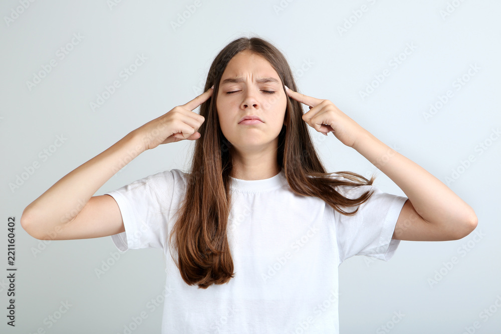 Young girl having headache on grey background Young girl having headache on grey background
